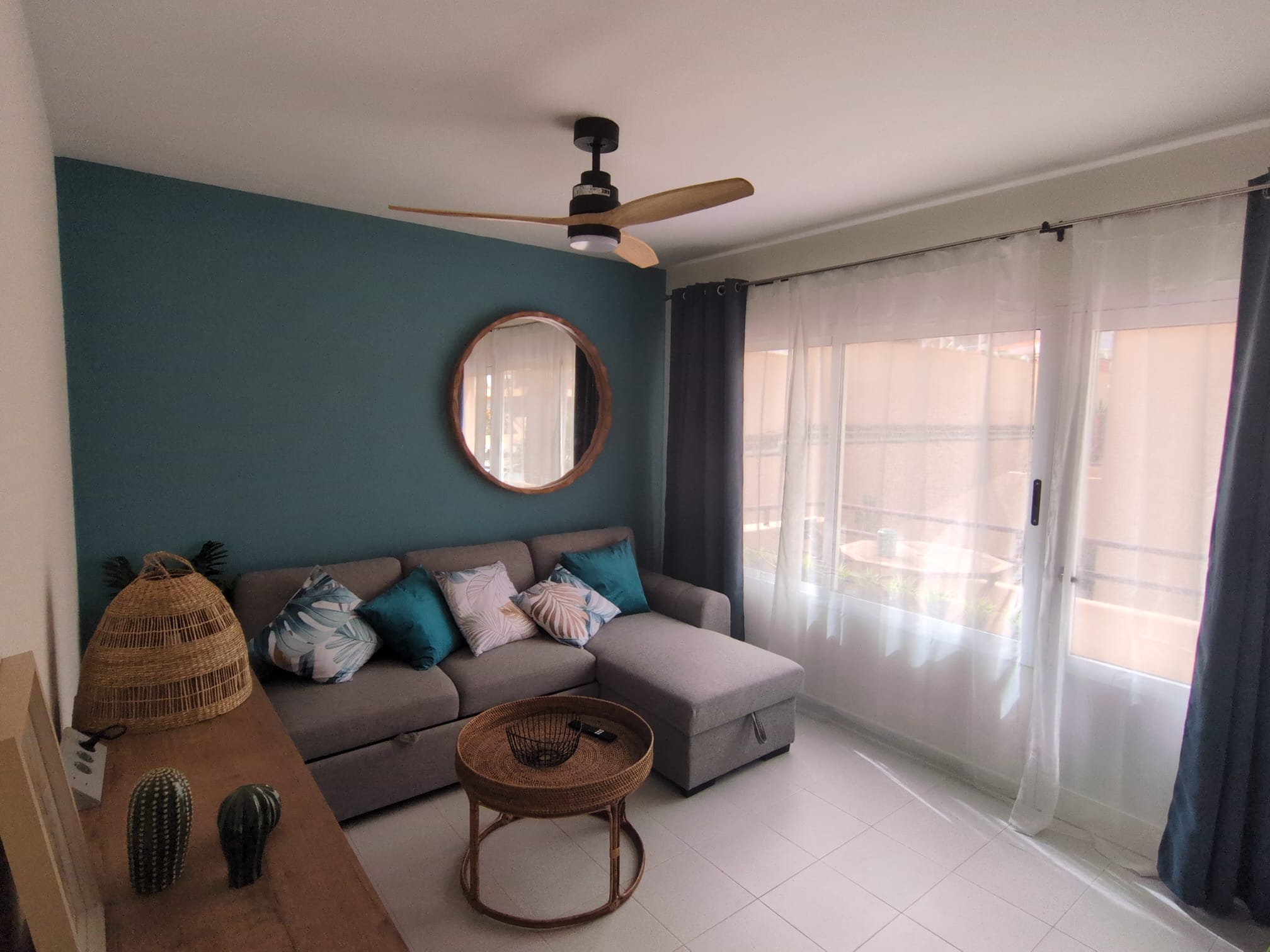 Salón luminoso con sofá cama y acceso a terraza